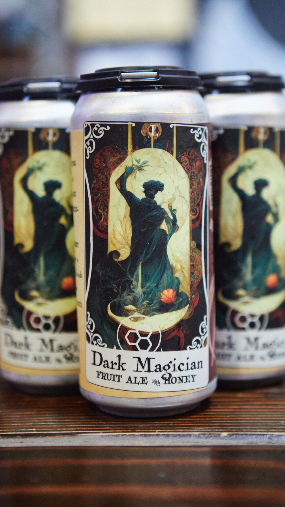 Row of Dark Magician fruit ale cans with tarot-card labels